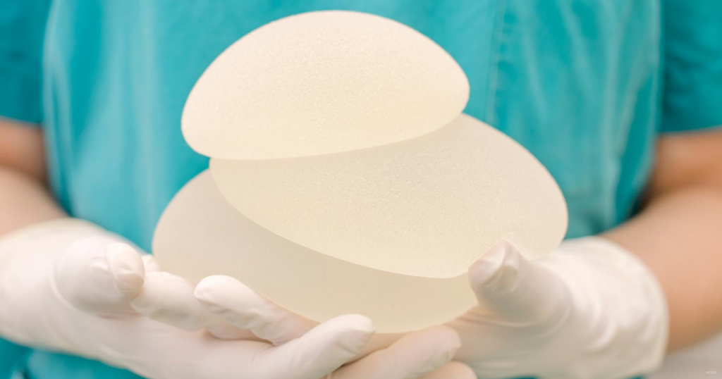 A doctor holds breast implant options.